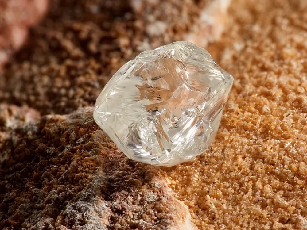A rough natural diamond resting in warm ore