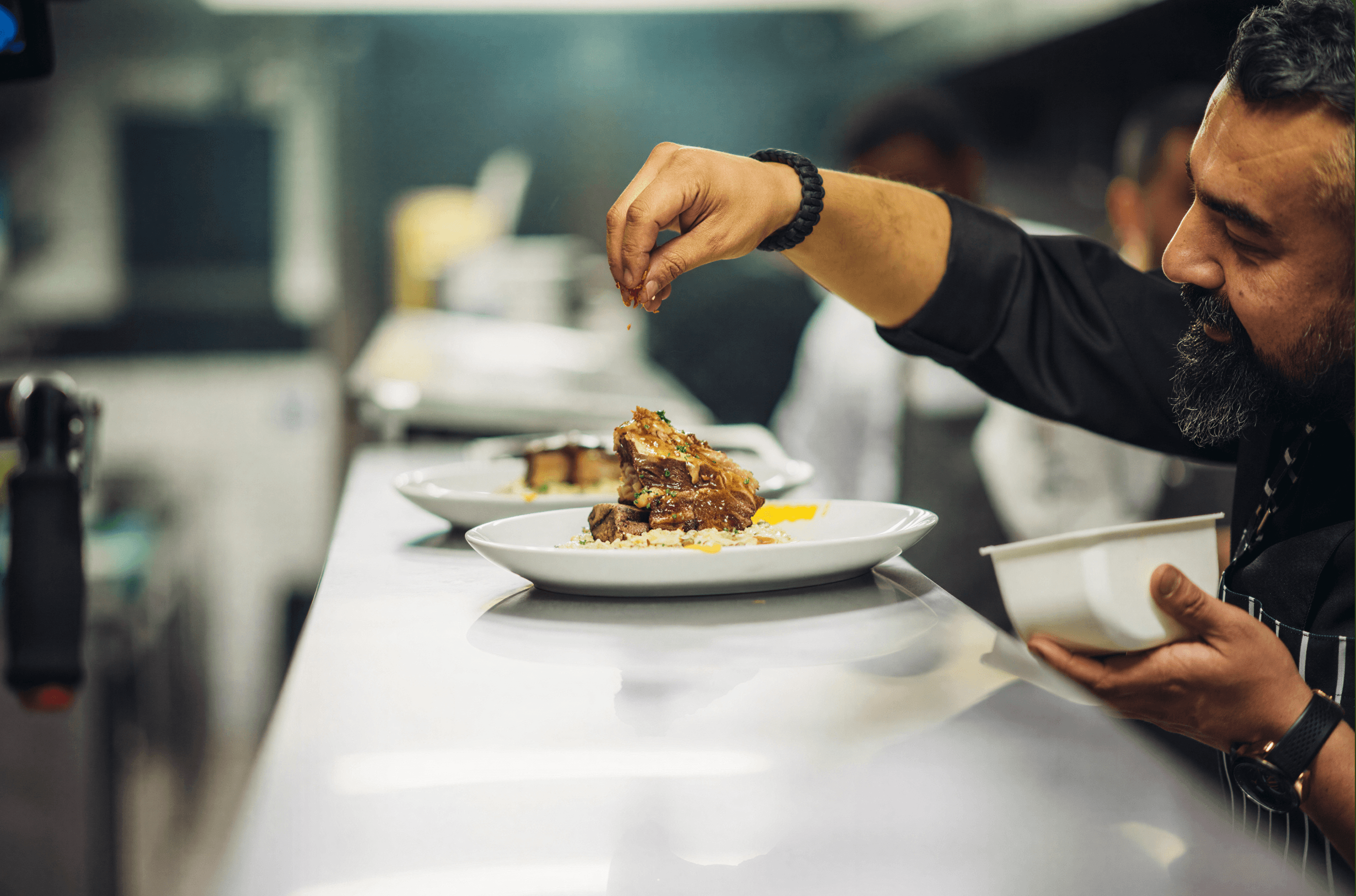 Chefs plating dishes in a professional kitchen